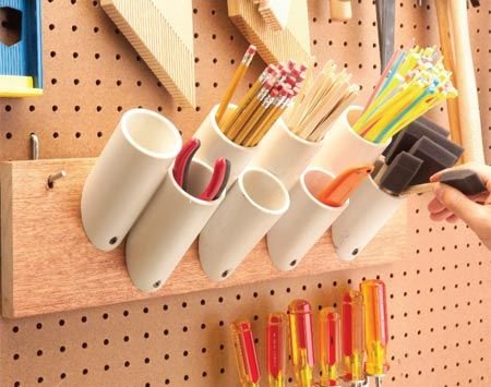 Cut PVC into short pieces and mount  on pegboard I have seen wider versions of this for a coatrack. That way you could put your phone, keys and wallet in the tube and hang your coat over it.